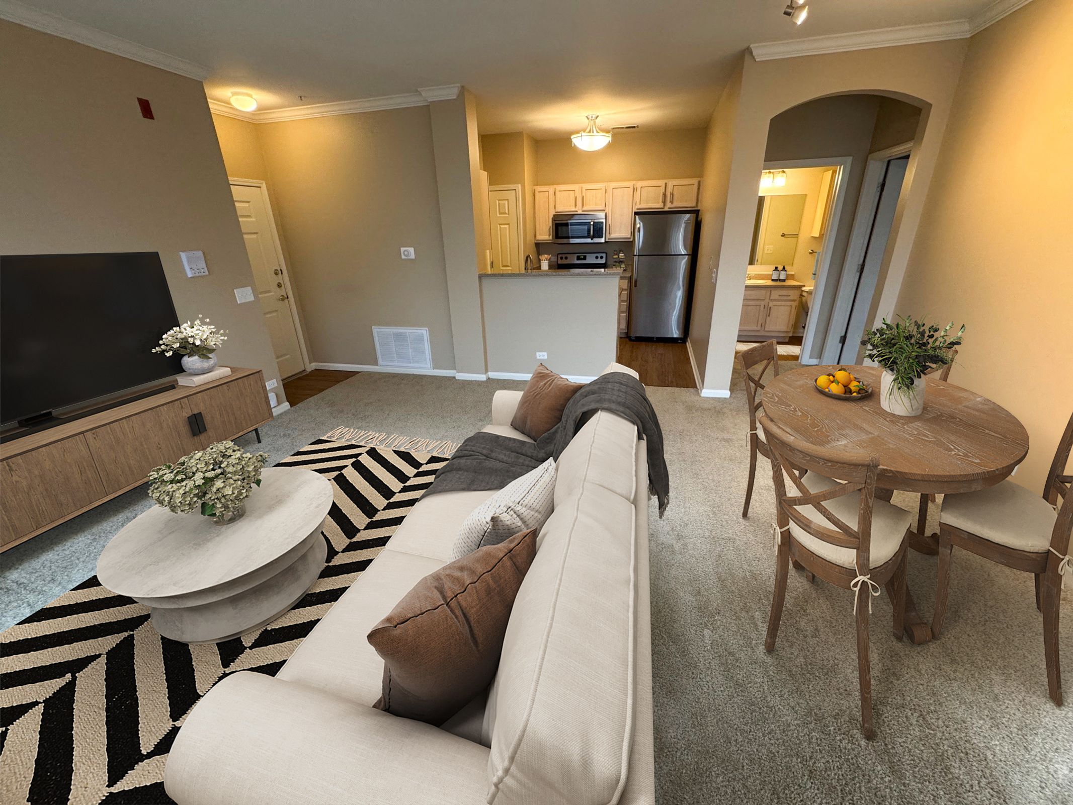 A living room with a white couch and a black and white rug.